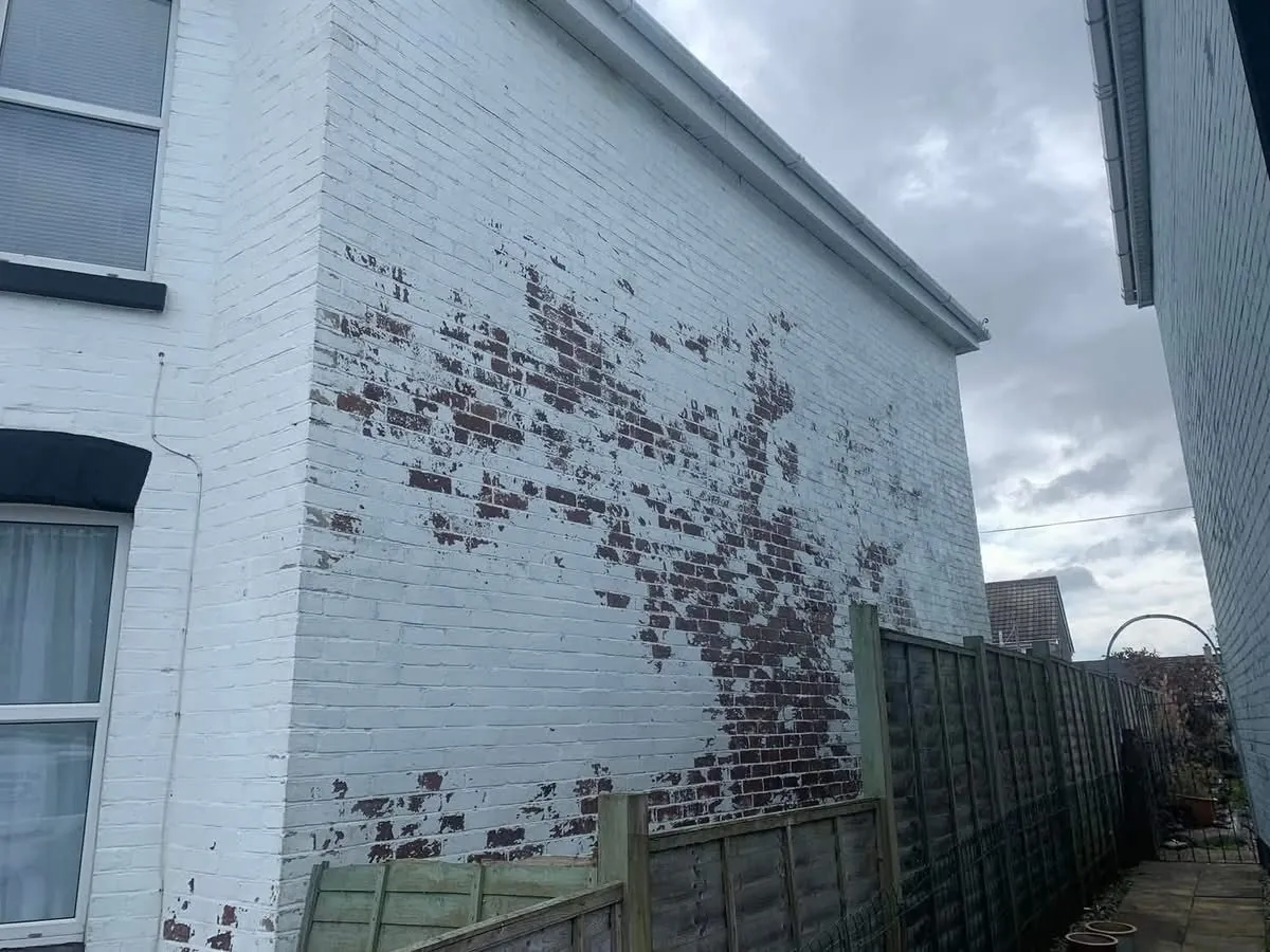 Peeling paint on a brick wall before redecoration in Bude